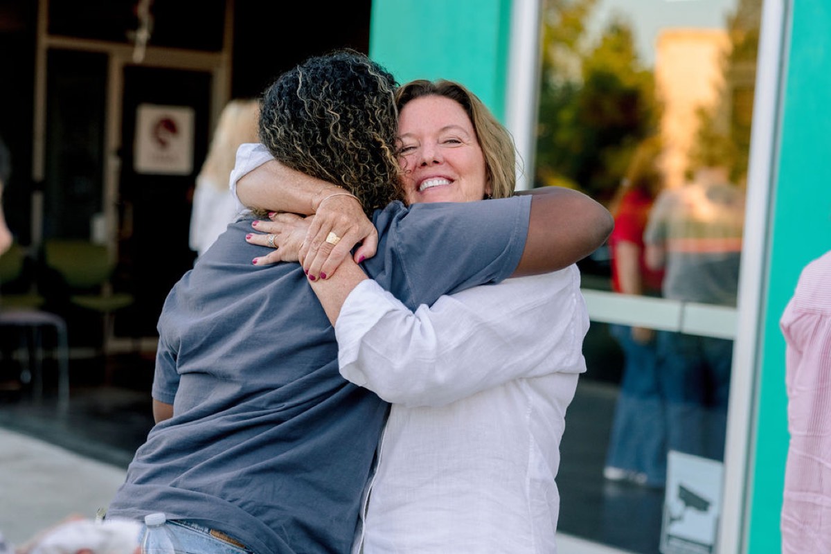 Karen embracing a student at the Orientation and Celebration